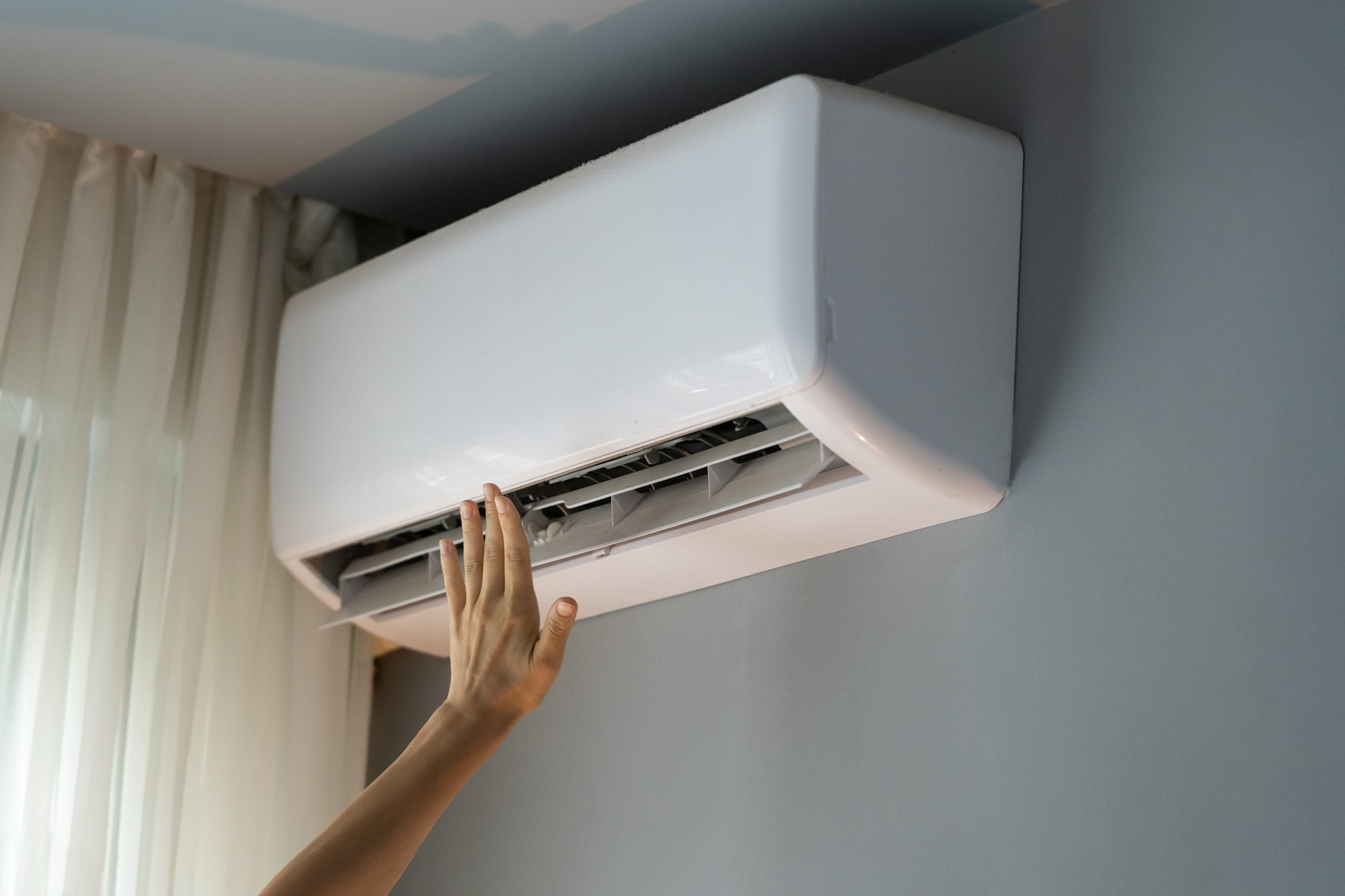 Hand adjusting home air conditioner indoor unit 2026 03 19 21 52 51 utc scaled